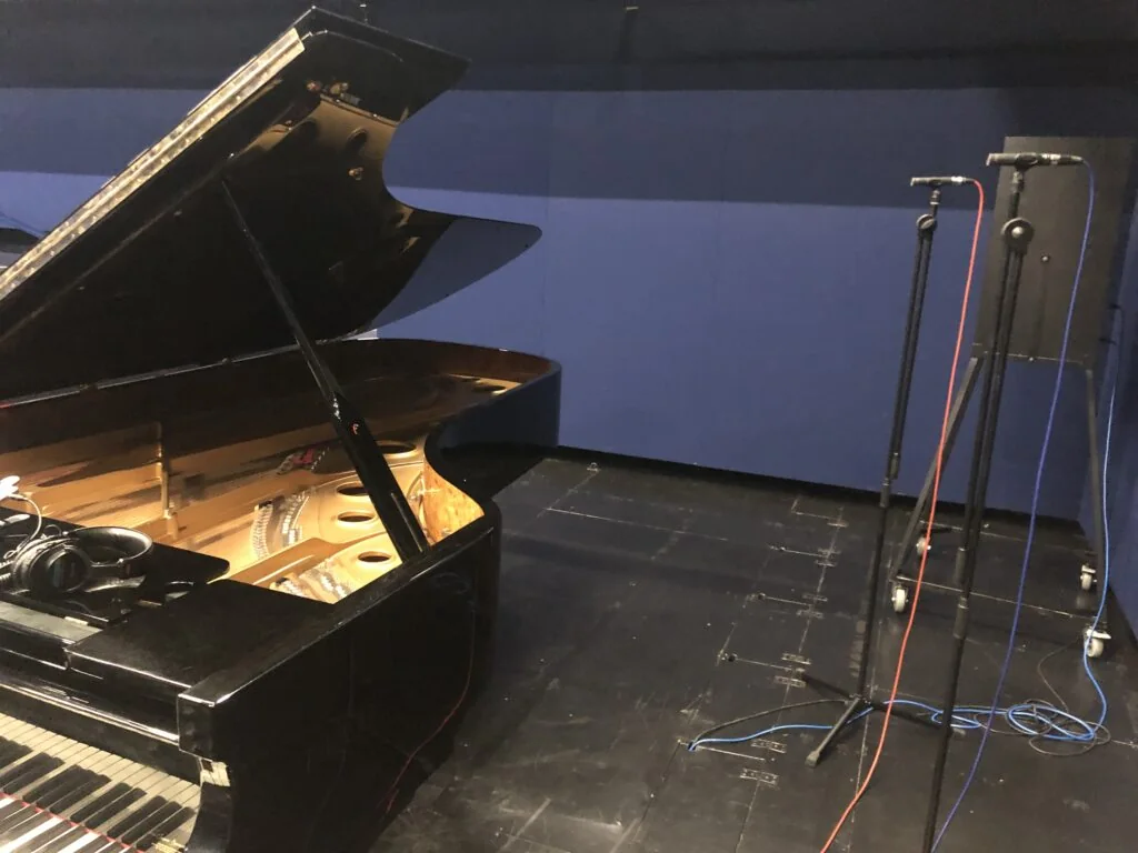 Grand piano in the studio with microphones on stands