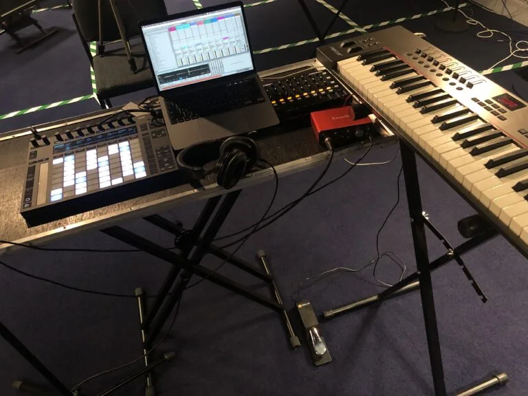 Production set-up with a laptop, pad controller, audio interface and keyboard