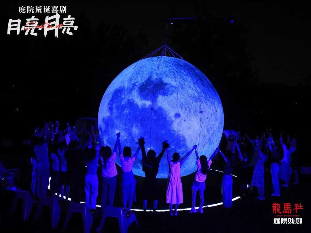 The Moon, The Moon: audience members joining hands in a circle around a large illuminated moon